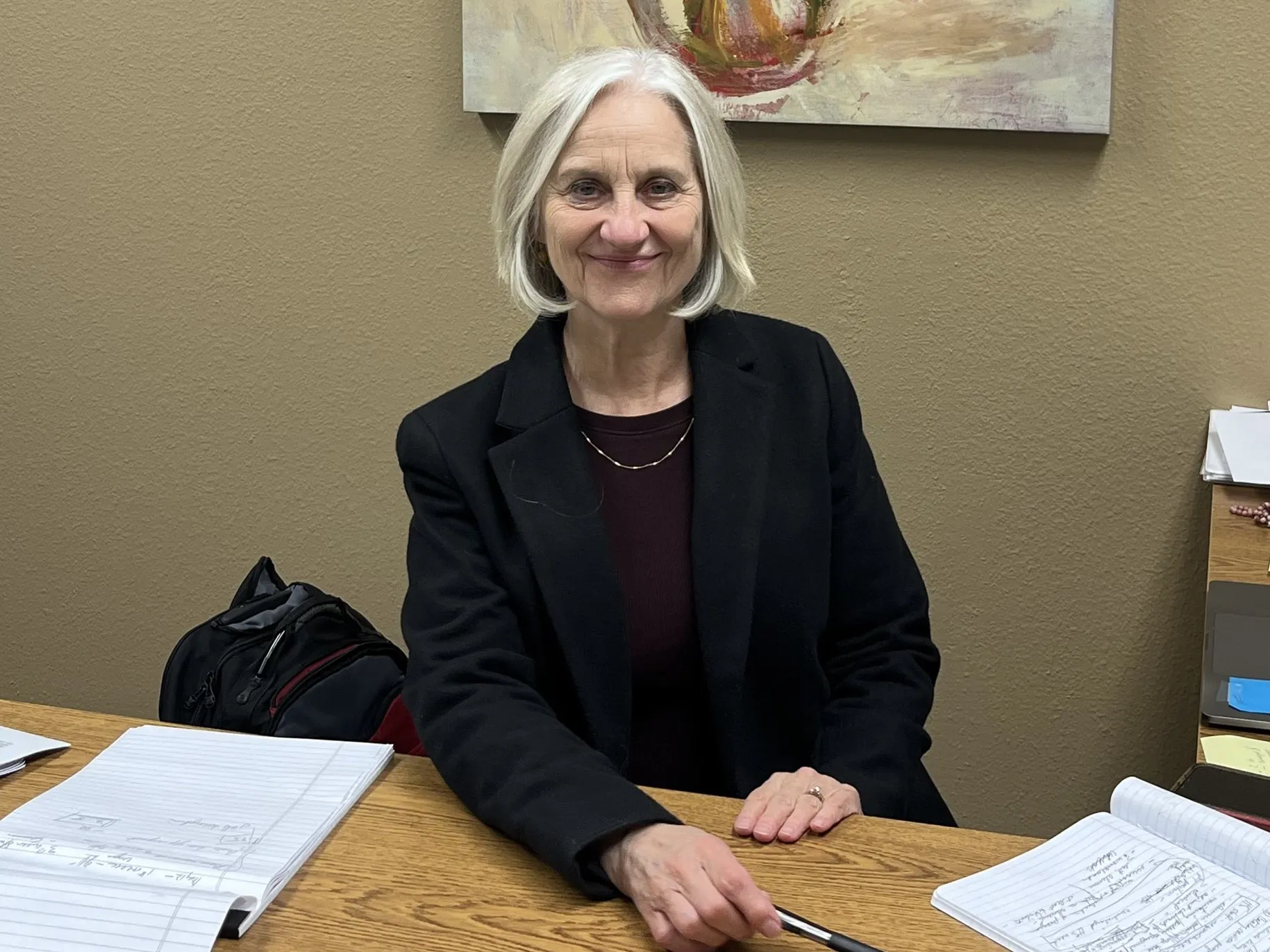 Susan Shore smiling for a picture at her office desk.