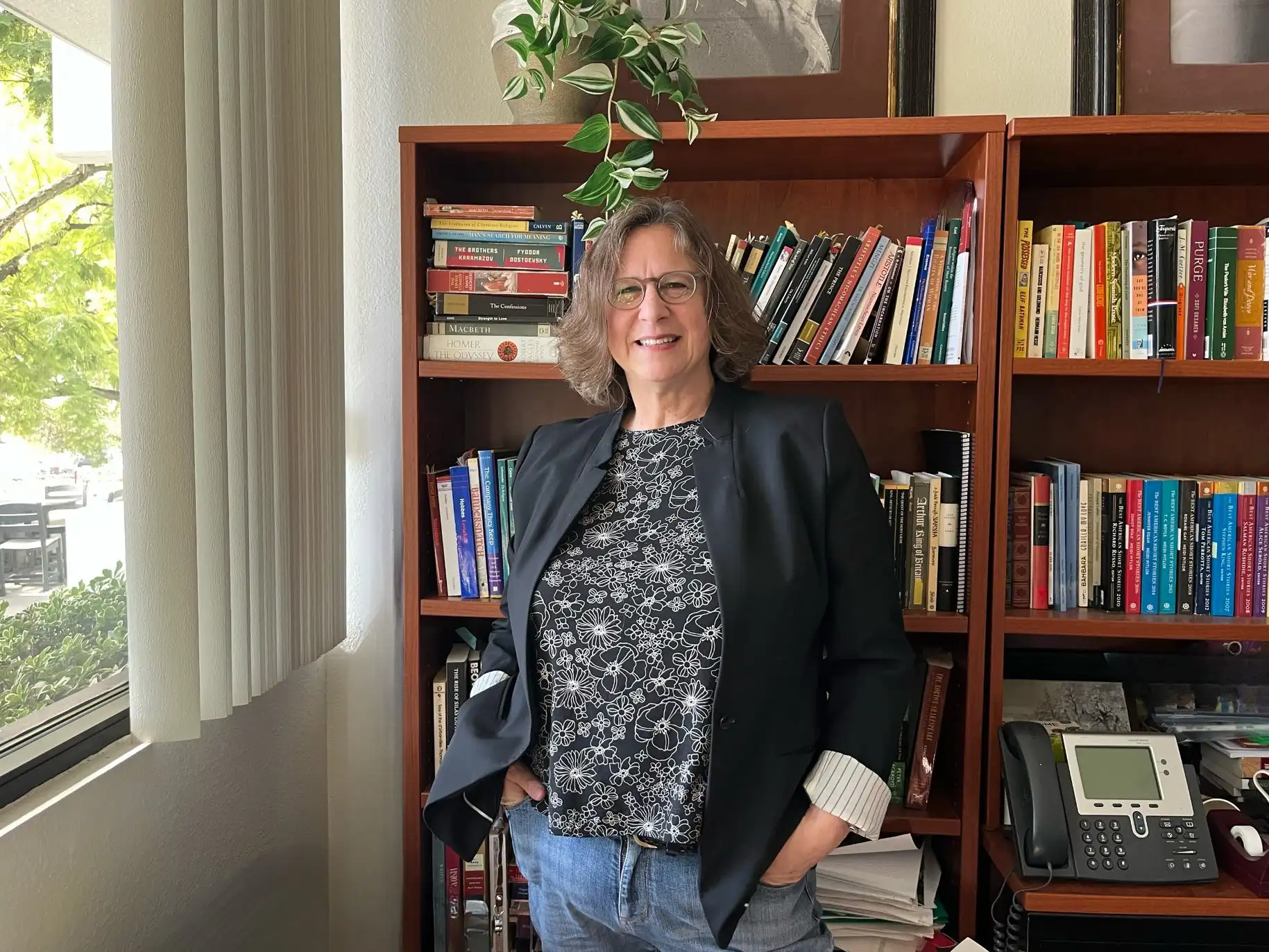 Christine Kern smiles for a picture in front of the bookshelves in her office.