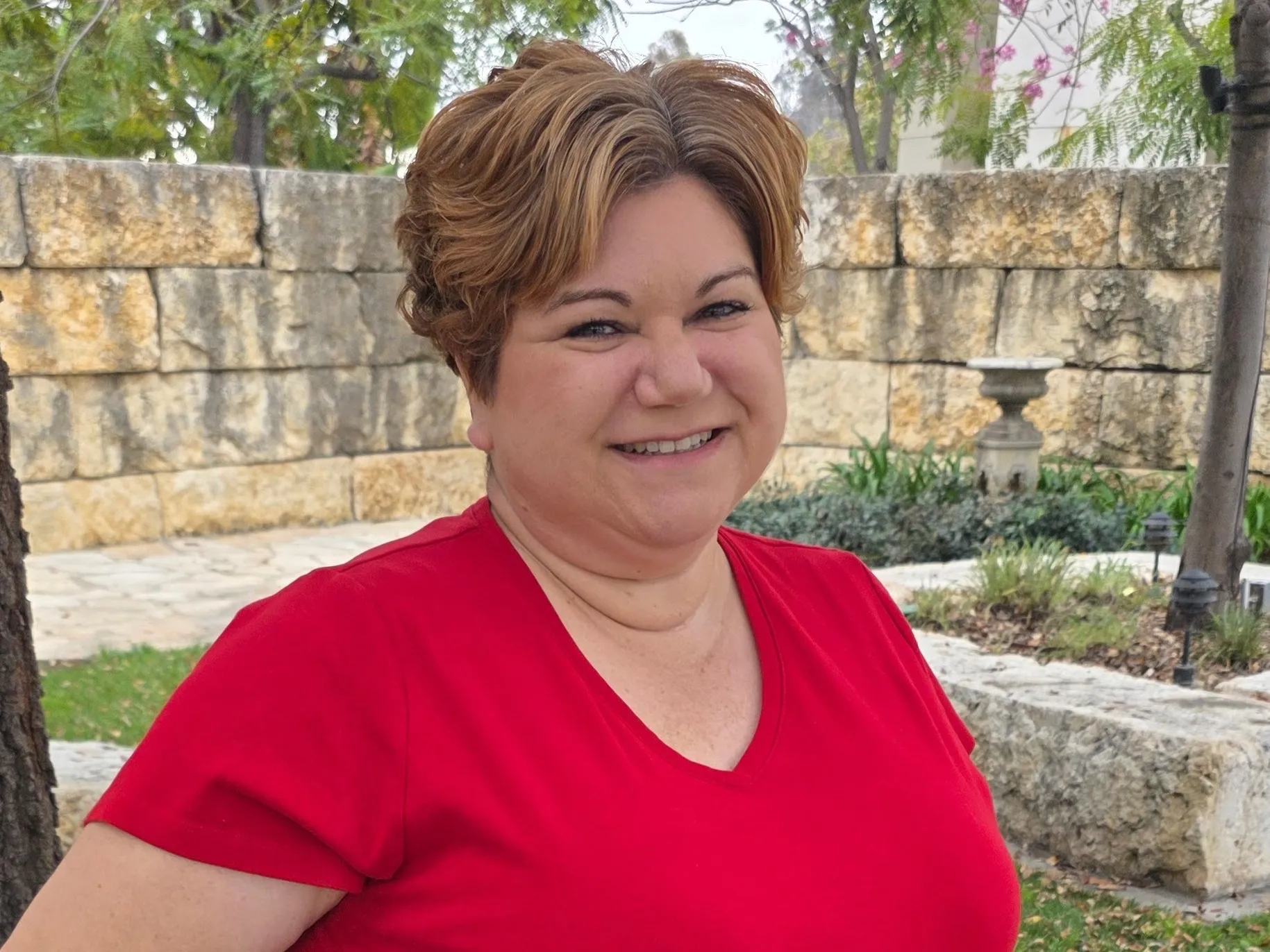 Dana smiles outside the prayer garden on west campus.