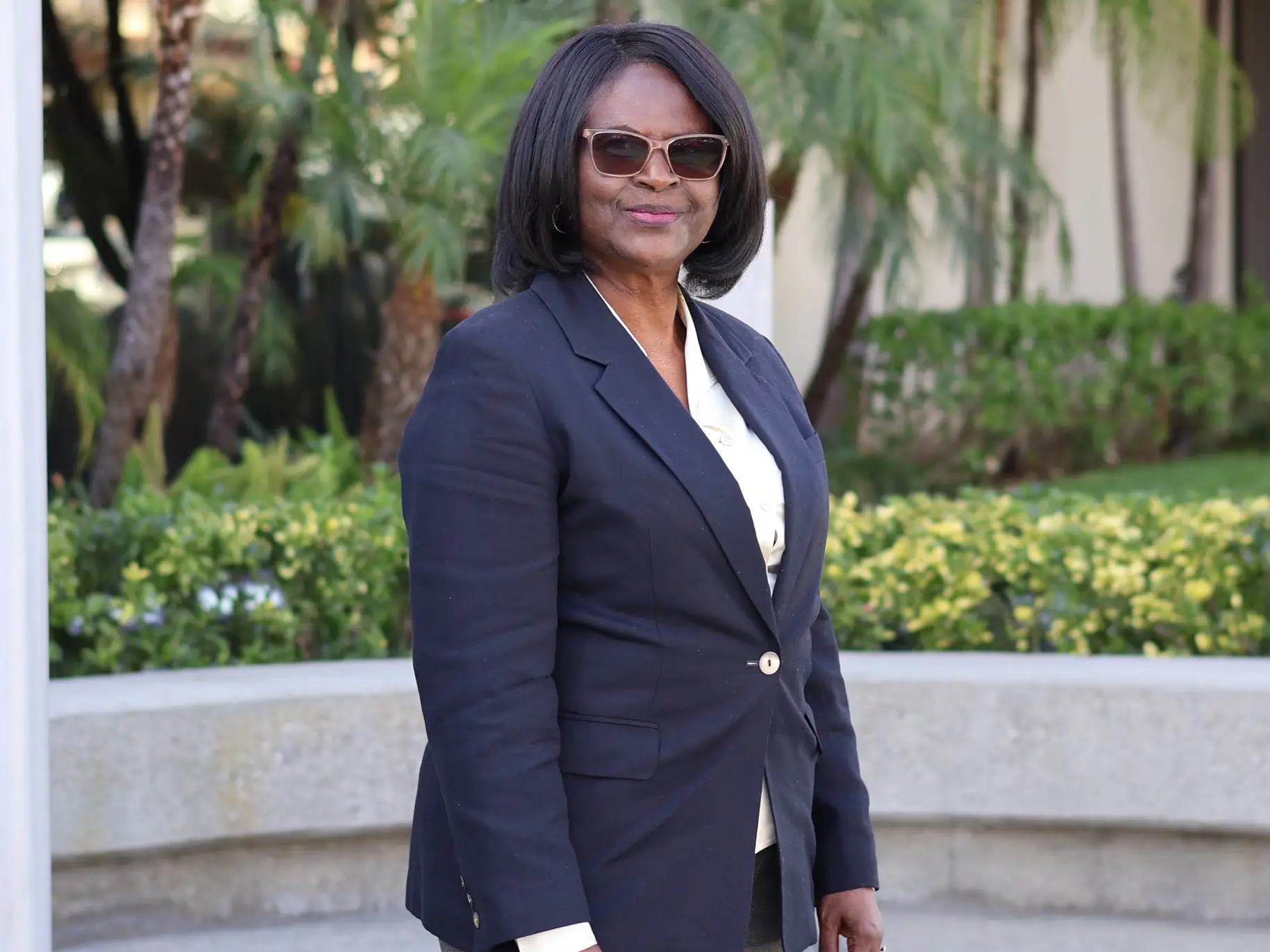 Marie Fongwa stands outside wearing a suit and smiling for a picture.